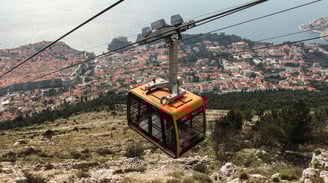 Teleférico em Dubrovnik com vista do alto para o mar.