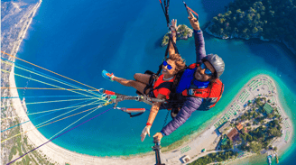 a man and woman parasailing over a body of water
