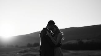 a couple hugging in an open landscape