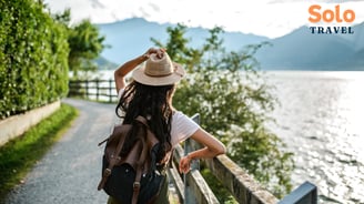 a woman in a hat and a backpacker on a path