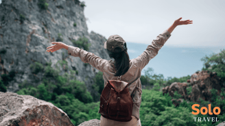 a woman with a backpack with her arms up and arms outstretched