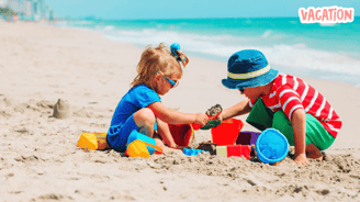 two children playing in the sand at the beach
