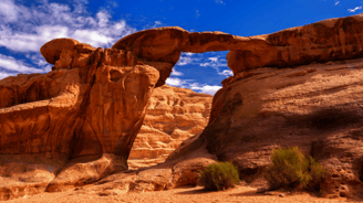a rock formation in the Wadi Rum, Jordan with a blue sky and clouds