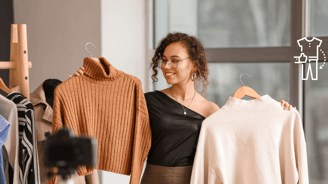 a woman holding a shirt and a sweater