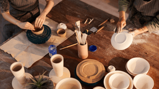 a woman is making a clay potted potted with a clay potted pot