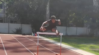 Jaison rakesh from pace sports is jumping over a hurdle on a track