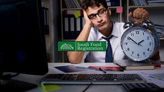 Frustrated man waiting on SFDA approval holding clock, symbolizing food product registration delays in Saudi Arabia.