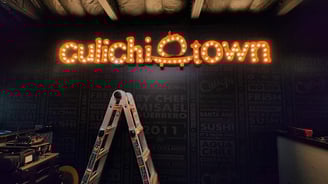 a ladder up to a sign that says culichi town