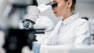 a woman in a lab coat and a microscope