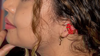 a woman with a red earring and earrings