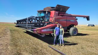 Ashley and her dad standing in front of a Case combine