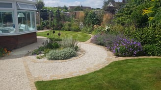 Artistic pathway and concentric circle garden feature made with sandstone setts and cotswold gravel.