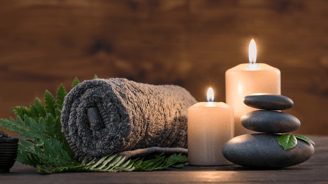 a stack of stones and candles with a roll of towels