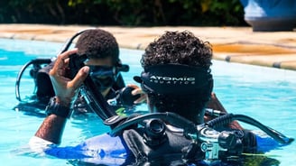 two people in scuba diving suits in a pool