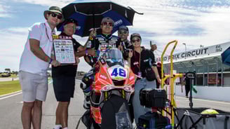 a group of people standing around a motorcycle