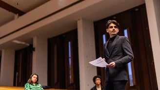 a man in a suit and tie is standing in front of a group of people