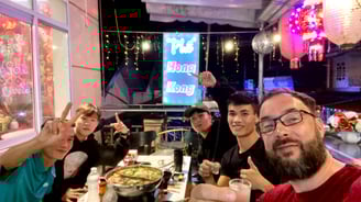a group of people sitting at a table with food