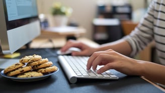 une femme travaille, devant elle une assiette de cookies appétissant. les cookies, C'est quoi ?