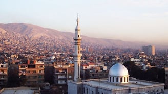 a mosque with a dome shaped building in the background