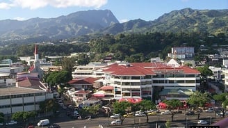 a city street scene with a mountain in the background