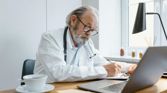 a male doctor in a white coat and a laptop