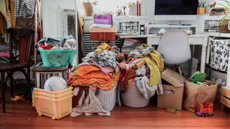 a messy desk surrounded by piles of clutter