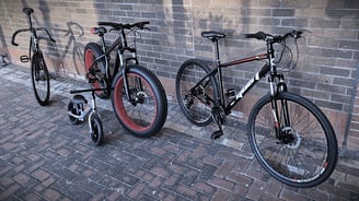 two bikes parked next to each other on a brick wall