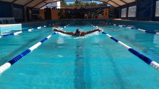 nadador por andarivel de piscina estilo mariposa