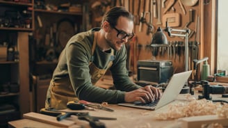 a man in a green shirt is working on a laptop