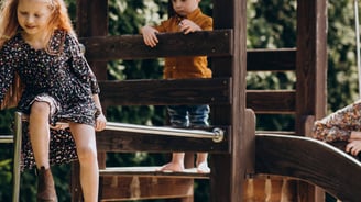 enfant jouant sur une cabane en bois