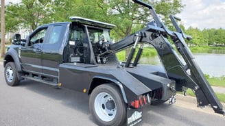 a black truck with a craned up to it's side