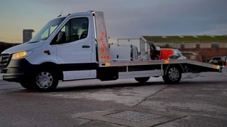 a white flat bed tow truck