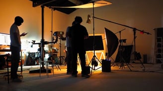 a man standing in front of a camera and a camera