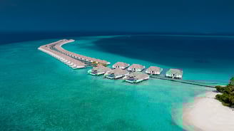 Villas located above sea water near boardwalk in Baa Atoll, Maldives
