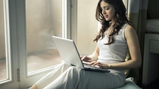 uma mulher com um notebook trabalhando na internet.