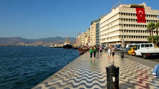 Vista do pier no porto de Izmir, com pessoas indo e vindo, capturando o movimento da cidade.