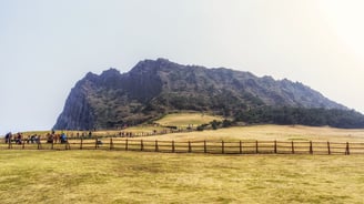Formação vulcânica de Seongsan Ilchulbong vista da trilha, com suas encostas verdes.