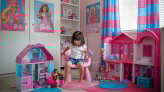 petite fille qui joue avec des poupée barbie