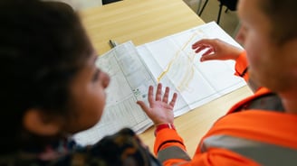 Profissionais avaliando mapa de regularização de imóvel