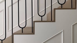 Custom staircase design with curved metal balusters and wood handrail for upscale interior