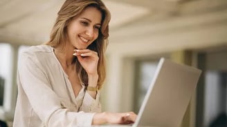 uma mulher sentada à mesa com um laptop
