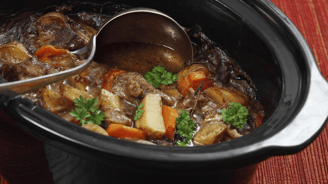 a spoonful of stew stew in a slow cooker