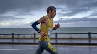 marathonien courant sous la pluie en bord de mer