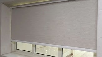 Modern blackout roller blind fully extended blocking out sunlight for complete privacy 
