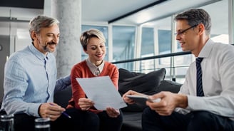 Happy couple and financial advisor going through plans during the meeting.