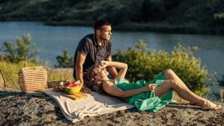 a man and woman sitting on a rock