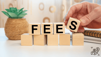 a person holding a wooden block with the word fees spelled in the letters