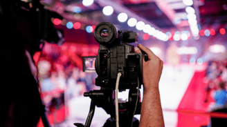 a person holding a camera and recording a fashion show