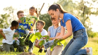 adults teaching homeschool children how to garden