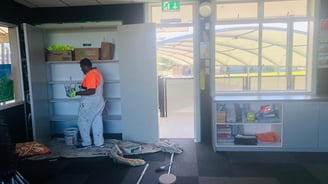 a man in a orange shirt is standing in front of a refrigerator